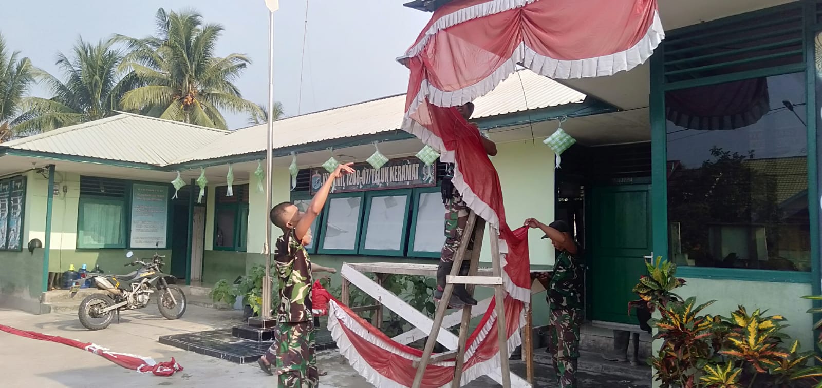 Jelang HUT Republik Indonesia Ke-80 Anggota Koramil 07/Teluk Keramat Pasang Bendera Merah Putih Dan Umbul- Umbul Di Makoramil