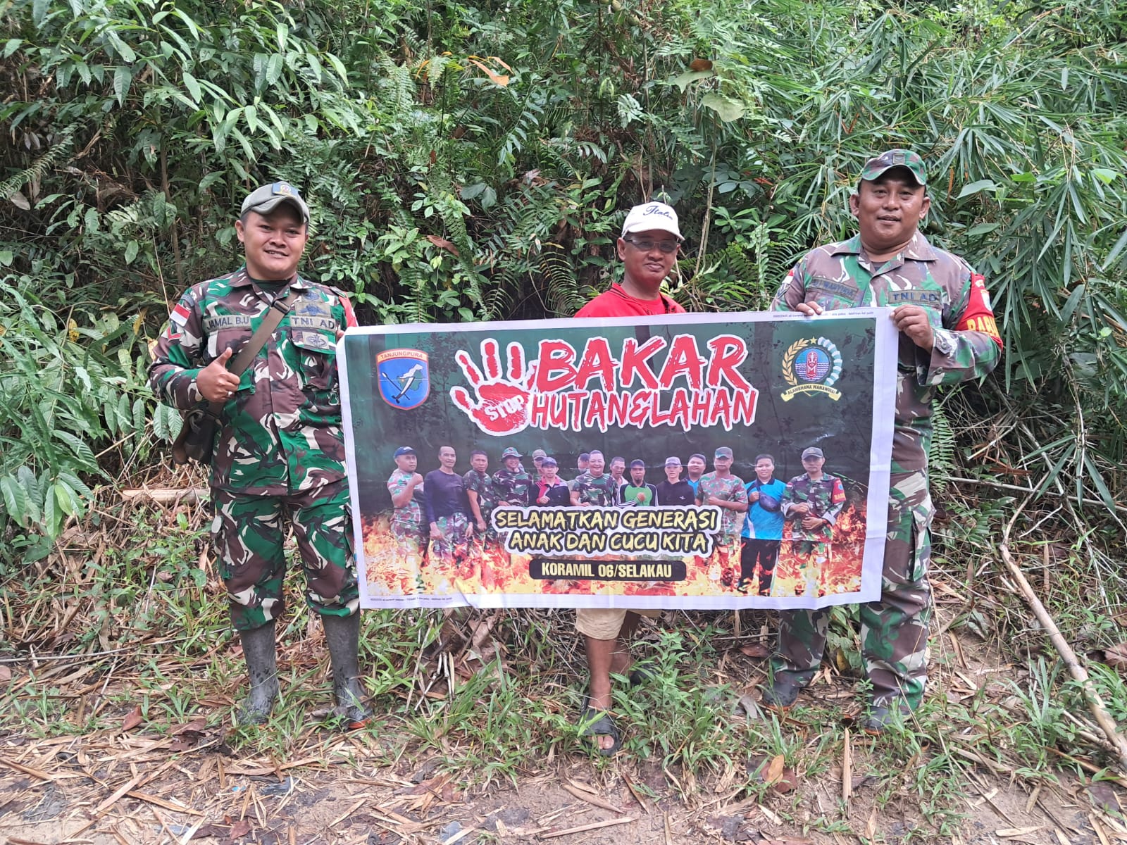 Anggota Koramil Jajaran Kodim 1208/Sambas Pasang Spanduk Dan Berikan Edukasi Himbauan Stop Membakar Hutan Kepada Warga
