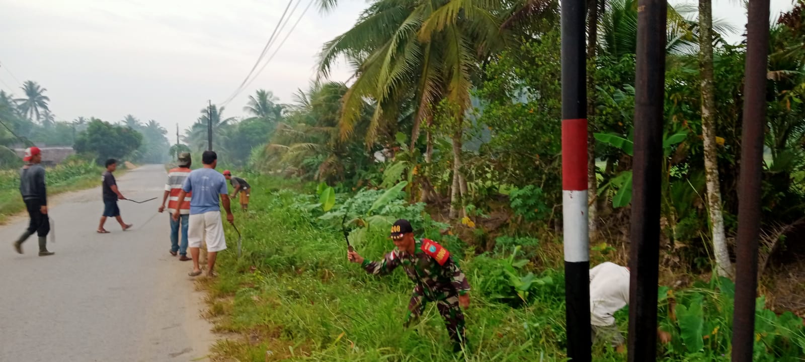 Ciptakan Lingkungan Yang Sehat Babinsa Sungai Toman Bersama Warga Gotong Royong Bersihkan Jalan Raya