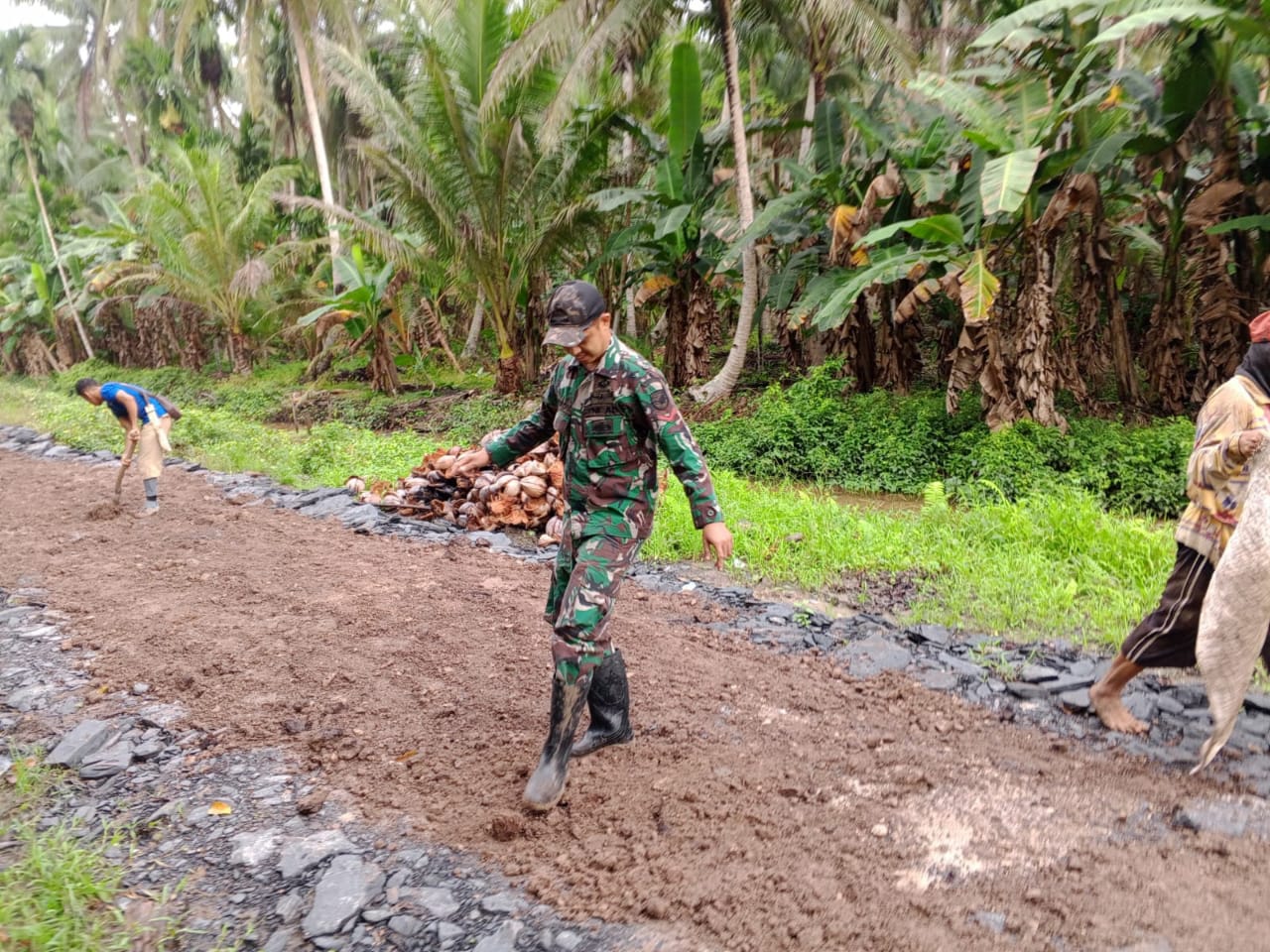 Sinergitas TNI Rakyat Anggota Koramil 04/Jawai Bersama Warga Gotong Royong Timbun Jalan